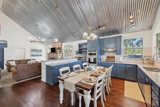 243 Riverbirch, Brookeland, TX 75931 - dining space with a chandelier, a fireplace, high vaulted ceiling, and dark wood-type flooring