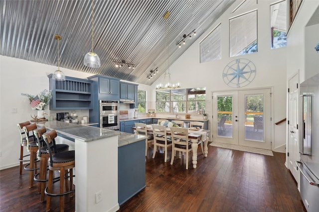 243 Riverbirch, Brookeland, TX 75931 - kitchen featuring blue cabinetry, high vaulted ceiling, a peninsula, open shelves, and track lighting