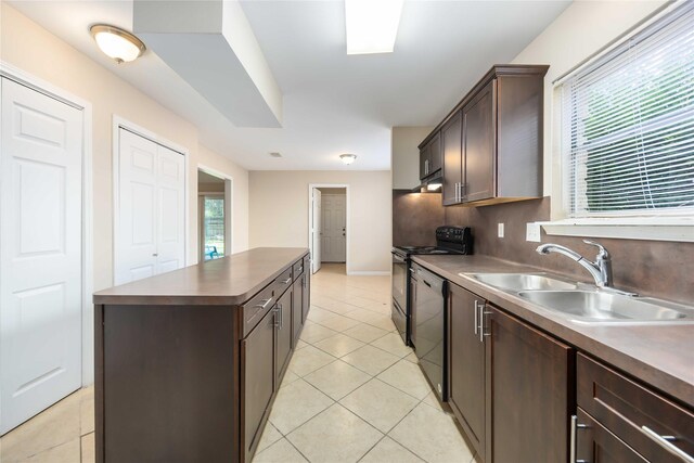 15615 Sandy Hill Dr, Houston, TX 77084 - kitchen with black stove, dishwashing machine, a kitchen island, dark brown cabinetry, and light tile patterned floors