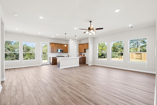 1613 Carefree Cir, Seabrook, TX 77586 - unfurnished living room with light wood-style flooring, a ceiling fan, and recessed lighting