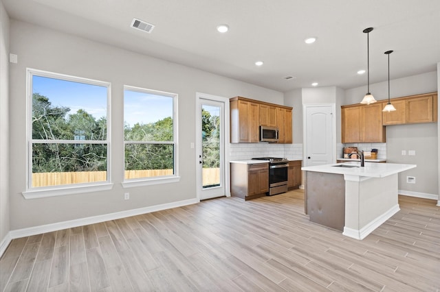 1613 Carefree Cir, Seabrook, TX 77586 - kitchen with appliances with stainless steel finishes, light countertops, tasteful backsplash, light wood finished floors, and pendant lighting