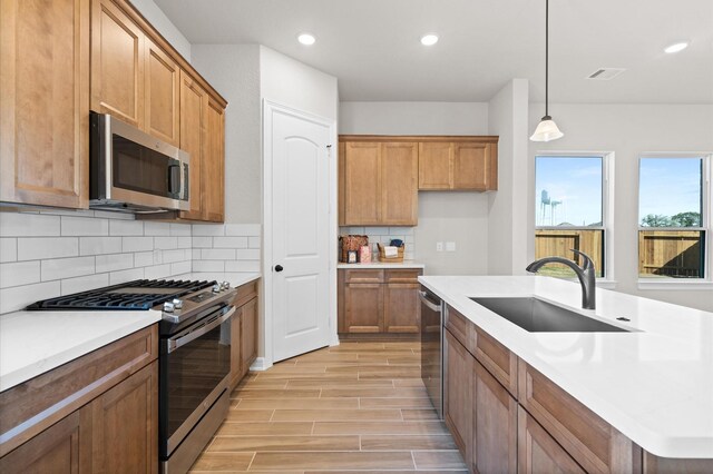 1613 Carefree Cir, Seabrook, TX 77586 - kitchen with stainless steel appliances, brown cabinets, recessed lighting, light wood-style floors, and light countertops