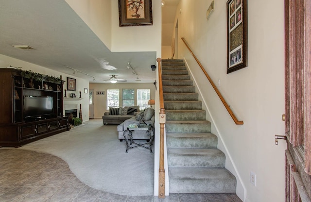 1010 Forestburg Dr, Spring, TX 77386 - stairs with rail lighting, tile patterned floors, carpet flooring, a fireplace, and ceiling fan