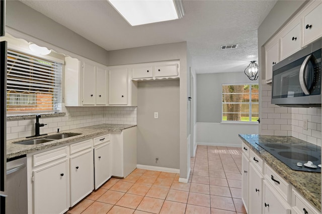 8214 Camborne Ln, Houston, TX 77070 - kitchen with appliances with stainless steel finishes, white cabinets, backsplash, light tile patterned floors, and light stone counters