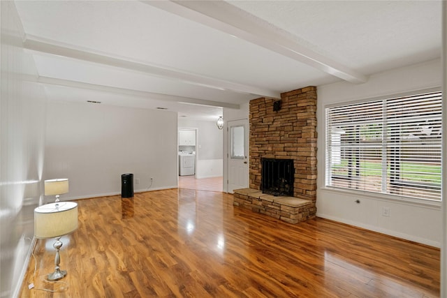 8214 Camborne Ln, Houston, TX 77070 - unfurnished living room with washer / clothes dryer, beamed ceiling, wood finished floors, and a fireplace