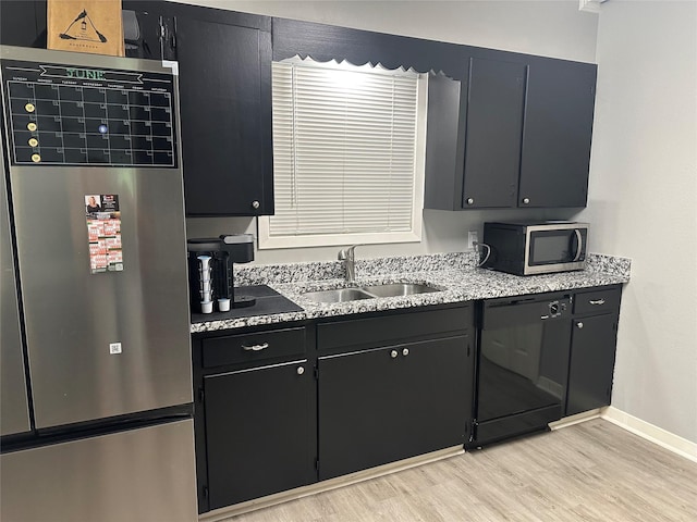 107 Southern Oaks Dr, Lake Jackson, TX 77566 - kitchen with refrigerator, black dishwasher, stainless steel microwave, light wood-style floors, and dark cabinets