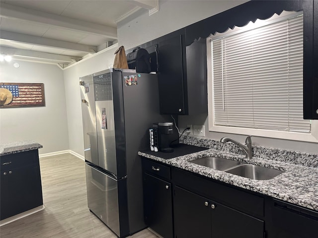 107 Southern Oaks Dr, Lake Jackson, TX 77566 - kitchen with dark cabinets, freestanding refrigerator, beamed ceiling, light wood-type flooring, and light stone countertops