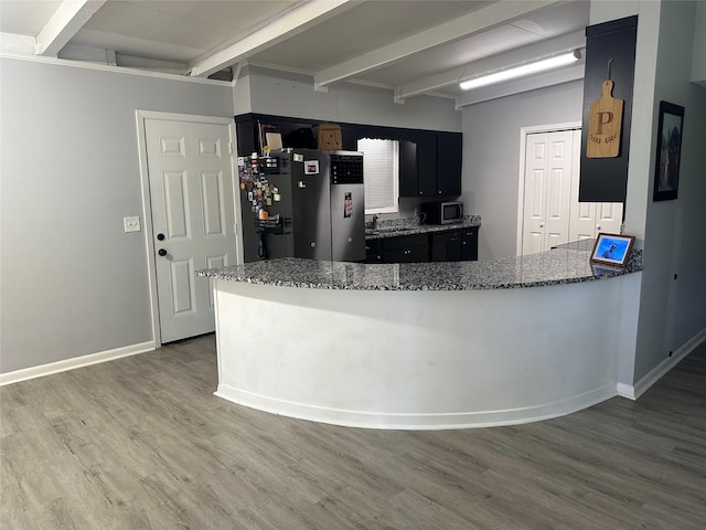 107 Southern Oaks Dr, Lake Jackson, TX 77566 - kitchen with beamed ceiling, appliances with stainless steel finishes, wood finished floors, dark cabinetry, and dark stone counters