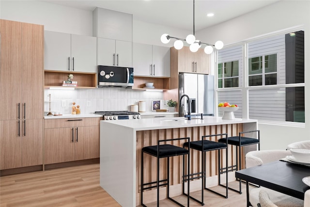 2948 Pitzlin St, Houston, TX 77023 - kitchen featuring stainless steel appliances, open shelves, a kitchen bar, light countertops, and recessed lighting