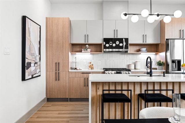 2948 Pitzlin St, Houston, TX 77023 - kitchen featuring open shelves, stainless steel appliances, light countertops, a kitchen breakfast bar, and backsplash