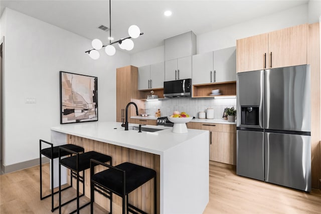 2948 Pitzlin St, Houston, TX 77023 - kitchen with appliances with stainless steel finishes, open shelves, tasteful backsplash, light wood finished floors, and light countertops