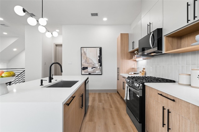 2948 Pitzlin St, Houston, TX 77023 - kitchen with stainless steel appliances, modern cabinets, light wood finished floors, open shelves, and backsplash