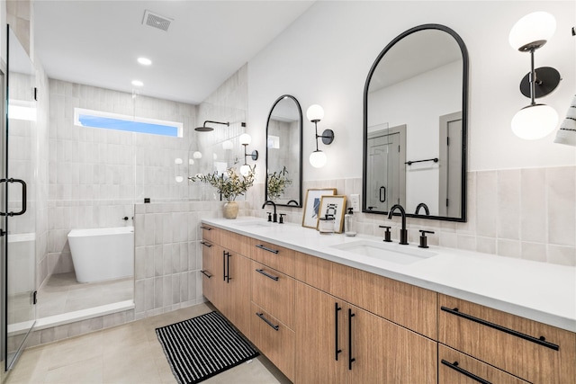 2948 Pitzlin St, Houston, TX 77023 - full bathroom featuring tile walls, tiled shower, double vanity, a freestanding bath, and tile patterned floors