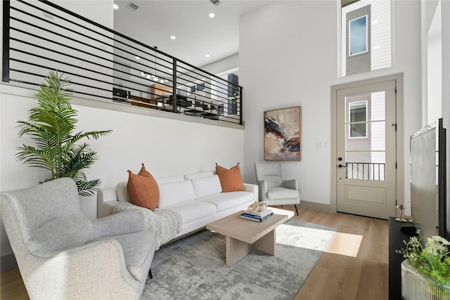 2948 Pitzlin St, Houston, TX 77023 - living area featuring wood finished floors, a towering ceiling, recessed lighting, and healthy amount of natural light