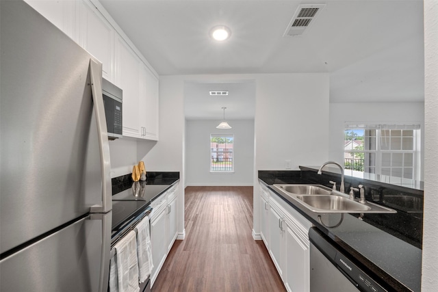 2800 Jeanetta St Unit 1206, Houston, TX 77063 - kitchen featuring appliances with stainless steel finishes, dark countertops, dark wood finished floors, and white cabinetry