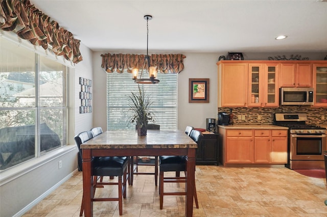 6027 Stone Trail Ln, Spring, TX 77379 - kitchen with appliances with stainless steel finishes, a chandelier, light stone finish floors, tasteful backsplash, and glass insert cabinets