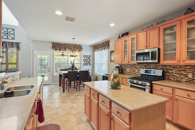6027 Stone Trail Ln, Spring, TX 77379 - kitchen featuring appliances with stainless steel finishes, decorative backsplash, a kitchen island, stone finish floors, and plenty of natural light