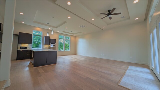 1844 Colquitt St, Houston, TX 77098 - kitchen featuring a raised ceiling, ceiling fan, dark cabinets, light countertops, and light wood-style flooring