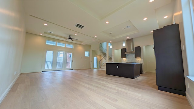 1844 Colquitt St, Houston, TX 77098 - kitchen featuring a raised ceiling, wall chimney range hood, a ceiling fan, tasteful backsplash, and open floor plan