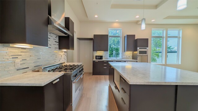 1844 Colquitt St, Houston, TX 77098 - kitchen featuring modern cabinets, high end stainless steel range oven, wall chimney exhaust hood, a raised ceiling, and decorative backsplash