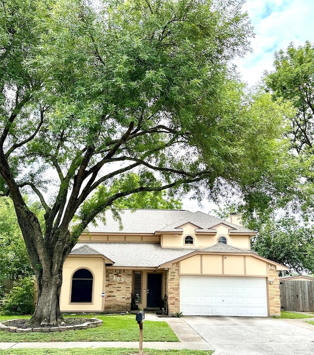 5103 Kleinbrook Dr, Houston, TX 77066 - view of front of property with an attached garage, concrete driveway, brick siding, stucco siding, and a shingled roof