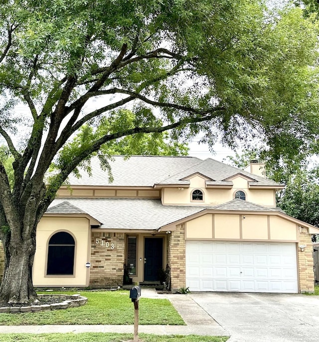 5103 Kleinbrook Dr, Houston, TX 77066 - view of front of house featuring an attached garage, concrete driveway, a front lawn, brick siding, and stucco siding