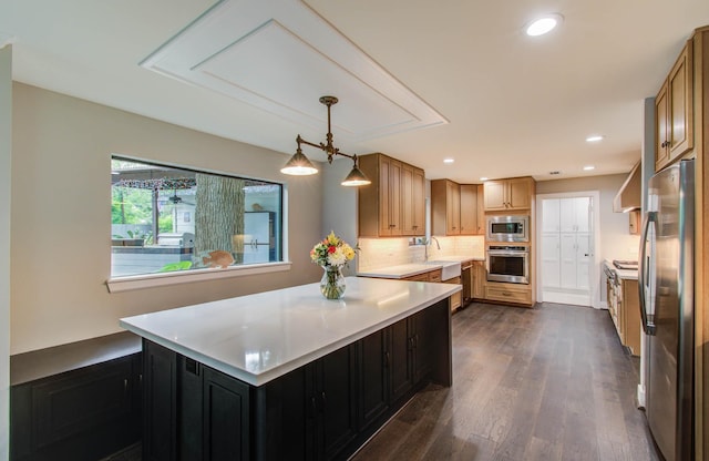 7922 Kleingreen Ln, Spring, TX 77379 - kitchen featuring appliances with stainless steel finishes, light countertops, dark wood-style flooring, a peninsula, and tasteful backsplash