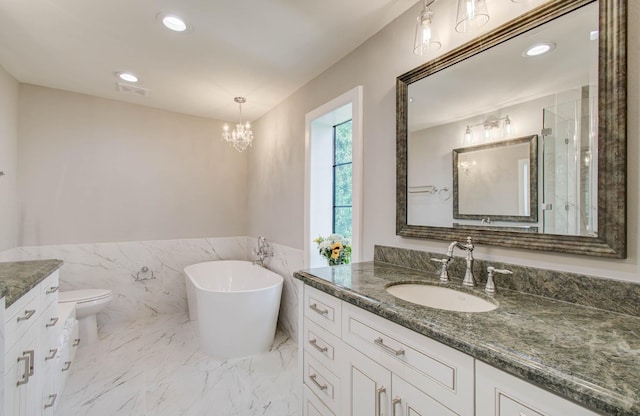 7922 Kleingreen Ln, Spring, TX 77379 - bathroom with vanity, a freestanding tub, wainscoting, tile walls, and a chandelier