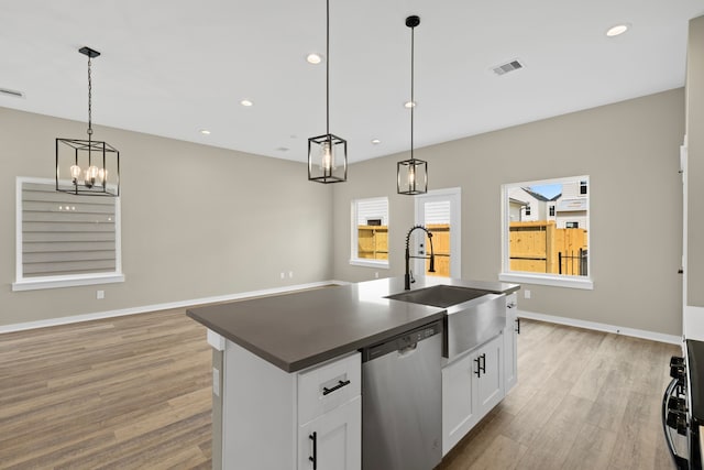 416 Stonework Landing Ln, Houston, TX 77076 - kitchen with dishwasher, light wood-type flooring, dark countertops, a kitchen island with sink, and white cabinetry
