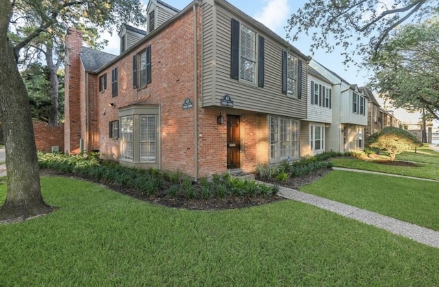 13050 Trail Hollow Dr, Houston, TX 77079 - view of front of home featuring brick siding, a front lawn, and a chimney