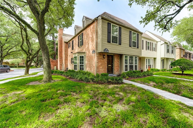 13050 Trail Hollow Dr, Houston, TX 77079 - townhome / multi-family property featuring brick siding, a chimney, and a front lawn