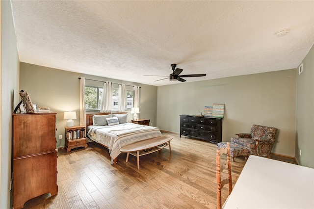 13050 Trail Hollow Dr, Houston, TX 77079 - bedroom featuring wood finished floors, a textured ceiling, and a ceiling fan