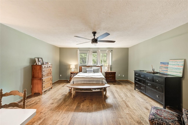 13050 Trail Hollow Dr, Houston, TX 77079 - bedroom with light wood-style flooring, a textured ceiling, and a ceiling fan