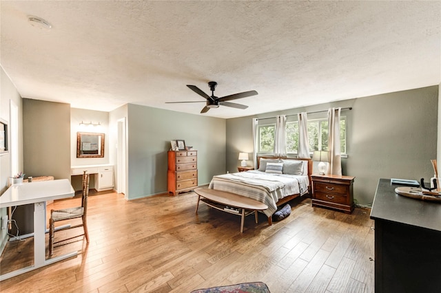 13050 Trail Hollow Dr, Houston, TX 77079 - bedroom with a textured ceiling, light wood-style floors, ceiling fan, and ensuite bathroom