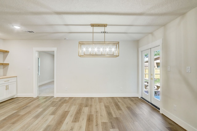 707 N Main St, Dayton, TX 77535 - unfurnished dining area with light wood finished floors, a chandelier, baseboards, and a textured ceiling