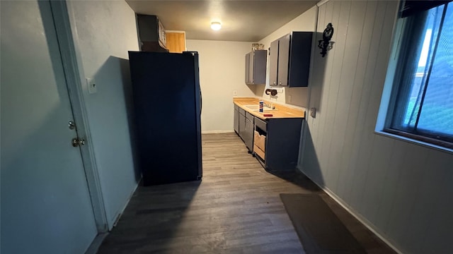 12414 Frazier River Dr, Houston, TX 77050 - kitchen featuring freestanding refrigerator, healthy amount of natural light, light countertops, wood finished floors, and wooden walls