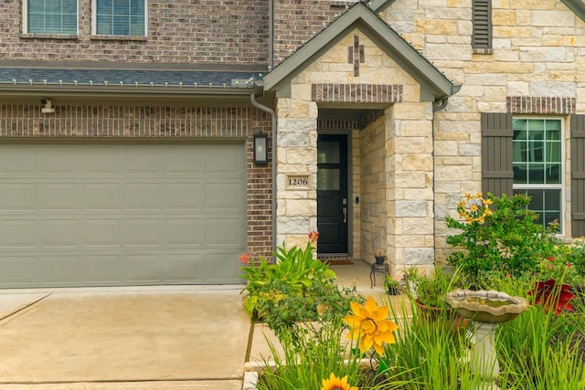 1206 Raburn Run Ln, Tomball, TX 77375 - view of exterior entry featuring concrete driveway, stone siding, and a garage