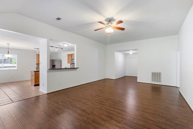 7023 Hayden Dr, Magnolia, TX 77354 - unfurnished living room with wood finished floors, a ceiling fan, rail lighting, and lofted ceiling