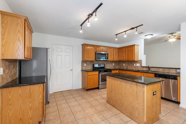 7023 Hayden Dr, Magnolia, TX 77354 - kitchen featuring appliances with stainless steel finishes, light tile patterned floors, decorative backsplash, a center island, and ceiling fan