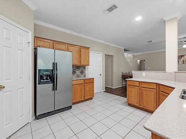 247 Private Road 635, Dayton, TX 77535 - kitchen featuring stainless steel fridge, light countertops, light tile patterned flooring, ornamental molding, and tasteful backsplash