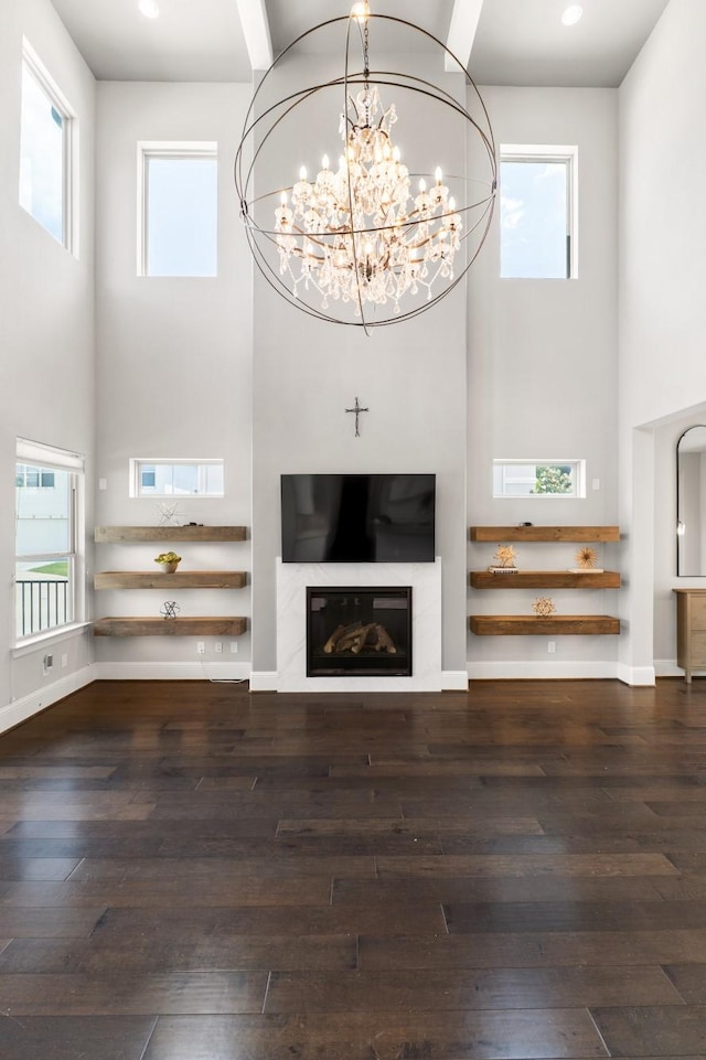 7714 S Fall Run Xing, Houston, TX 77055 - unfurnished living room featuring a towering ceiling, wood-type flooring, a chandelier, recessed lighting, and a glass covered fireplace