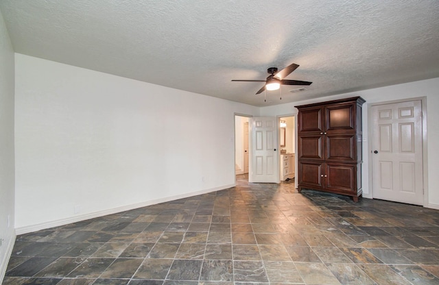 14507 Louetta Rd, Cypress, TX 77429 - unfurnished bedroom with dark stone finish floors, a textured ceiling, and a ceiling fan