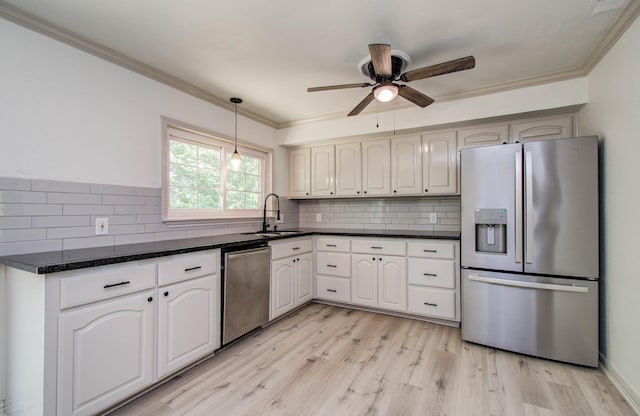 14507 Louetta Rd, Cypress, TX 77429 - kitchen featuring stainless steel appliances, a ceiling fan, crown molding, light wood finished floors, and backsplash