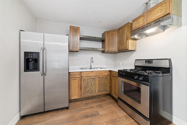 507 S Kansas St, La Porte, TX 77571 - kitchen featuring appliances with stainless steel finishes, open shelves, under cabinet range hood, wood finished floors, and light countertops