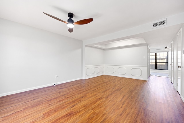 10328 Longmont Dr Unit 47/1, Houston, TX 77042 - spare room with wood finished floors, ceiling fan, wainscoting, and a decorative wall