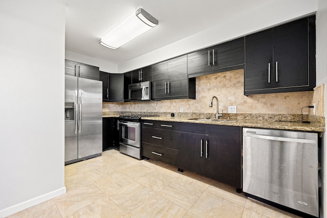 10328 Longmont Dr Unit 47/1, Houston, TX 77042 - kitchen with appliances with stainless steel finishes, dark cabinets, backsplash, and light stone countertops