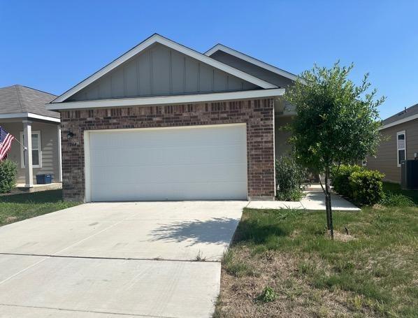 12614 Galatea, San Antonio, TX 78245 - view of front of property featuring board and batten siding, brick siding, concrete driveway, and a garage