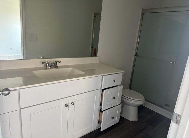 12614 Galatea, San Antonio, TX 78245 - bathroom with vanity, a shower stall, and wood finished floors