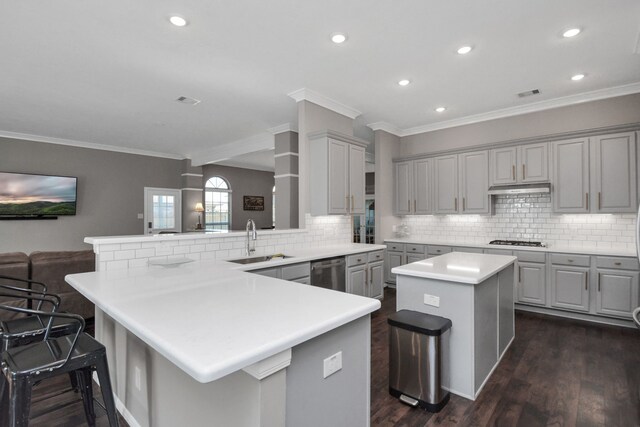 2808 Apache St, League City, TX 77573 - kitchen featuring gray cabinetry, a breakfast bar, white gas cooktop, a peninsula, and stainless steel dishwasher