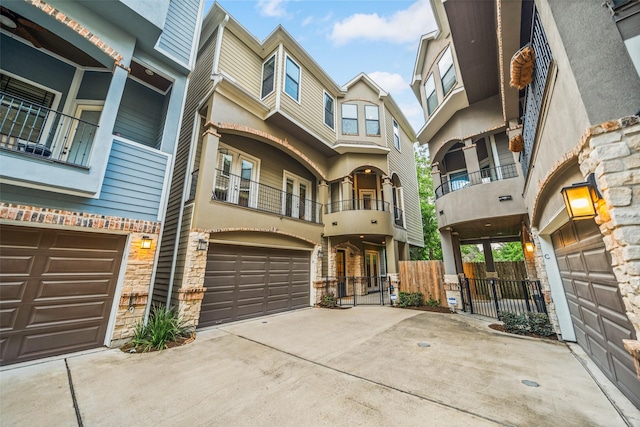 1219 W 25th St Unit D, Houston, TX 77008 - view of front facade with stone siding, a balcony, a gate, driveway, and a garage